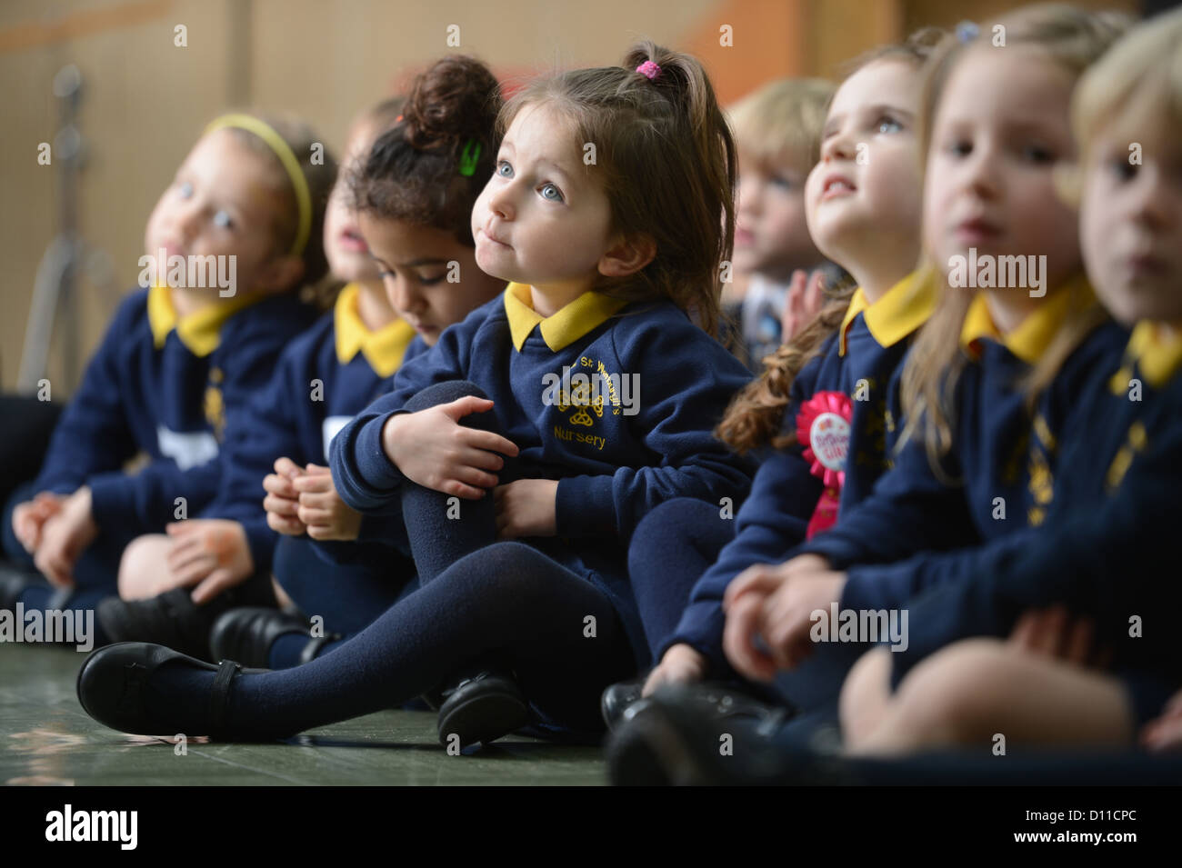 Los niños en la reunión matinal en la Virgen y San Werburgh la escuela primaria católica en Newcastle-under-Lyme, Staffordshire REINO UNIDO Foto de stock