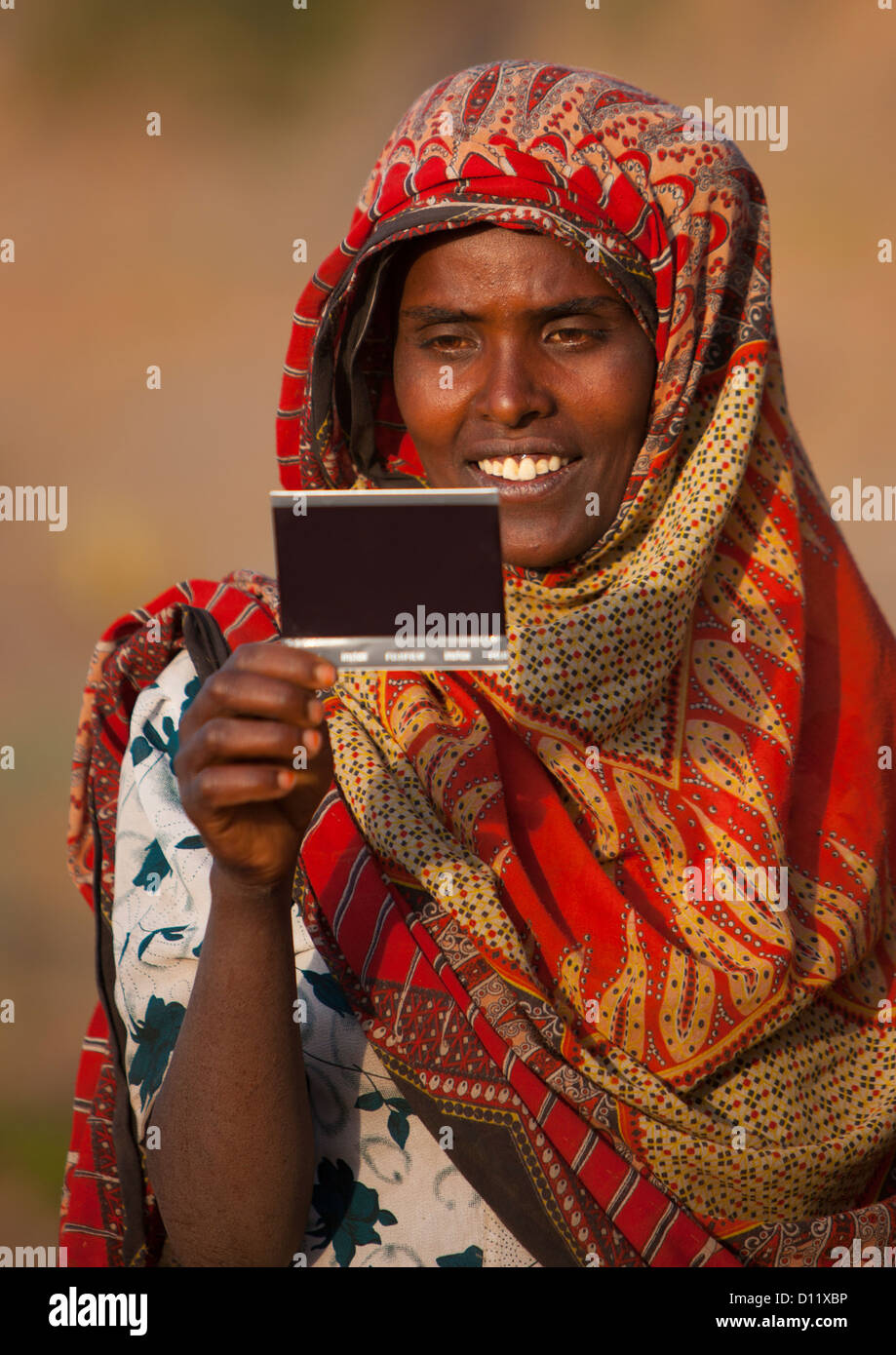 Retrato de una mujer con gran sonrisa viendo a sí misma en la imagen por primera vez, Dire Dawa, Etiopía Foto de stock