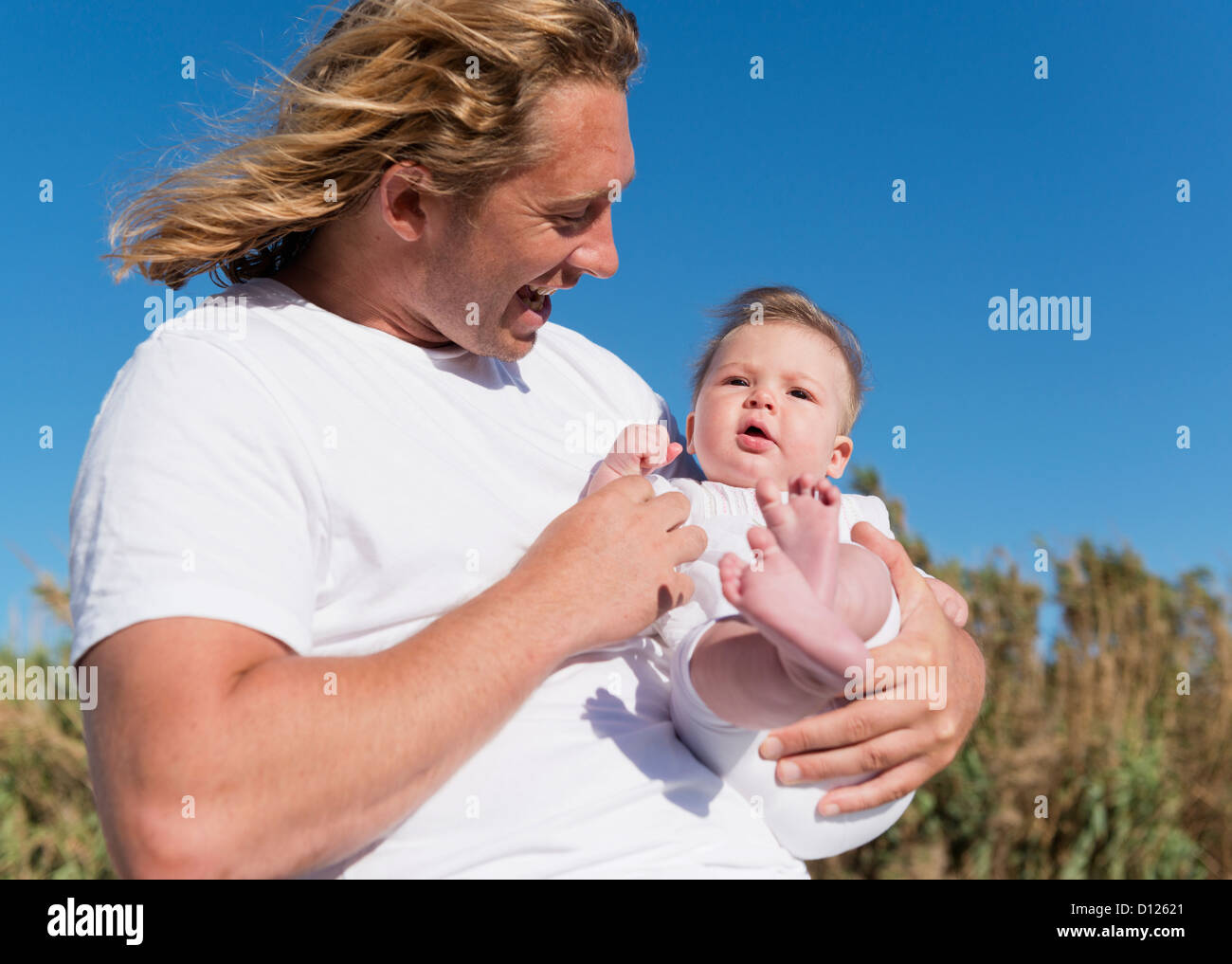 Un padre sostiene a su bebé; Tarifa Cádiz Costa de la Luz Andalucía España Foto de stock