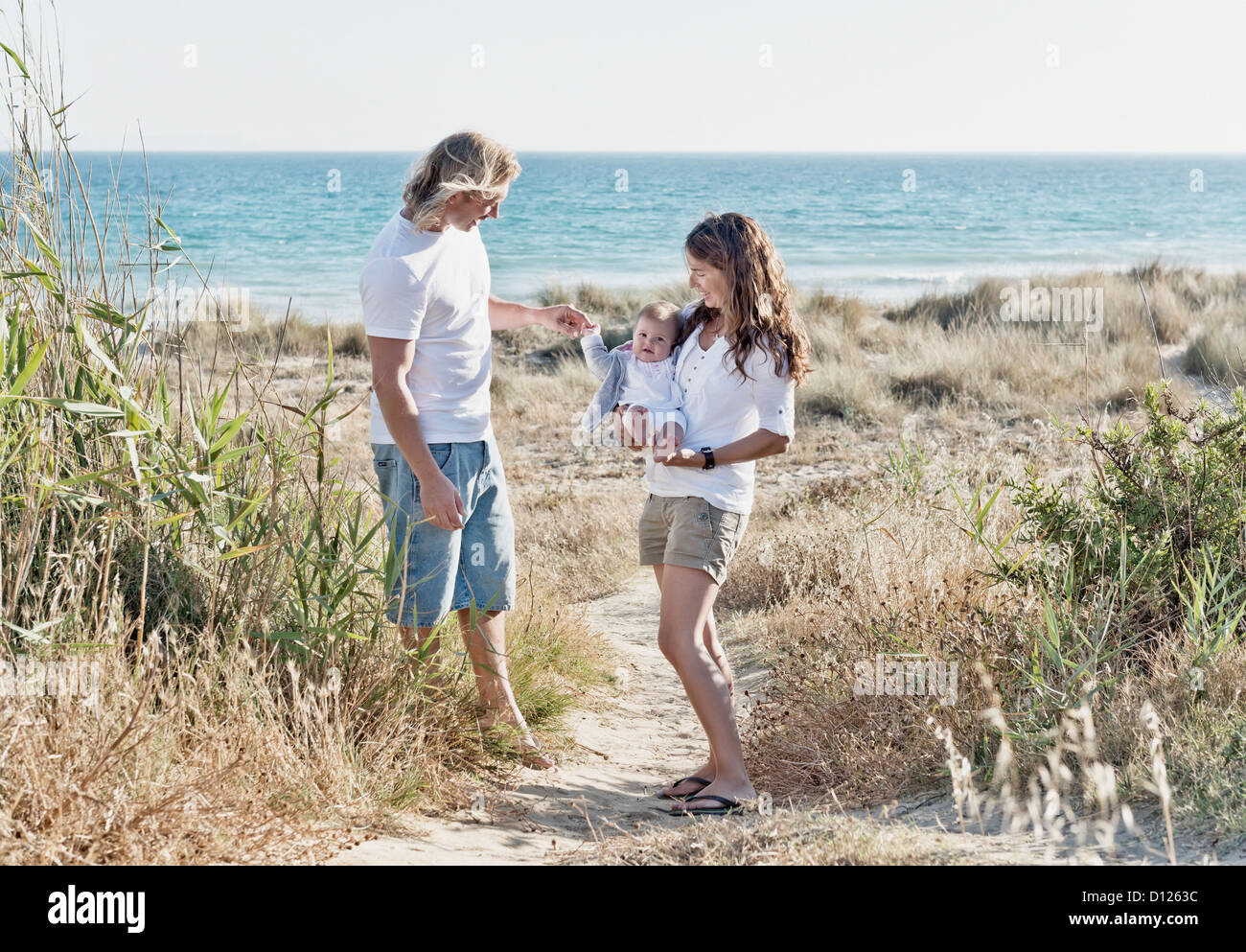 Una madre y un padre con el bebé en la playa; Tarifa Cádiz Costa de la Luz Andalucía España Foto de stock