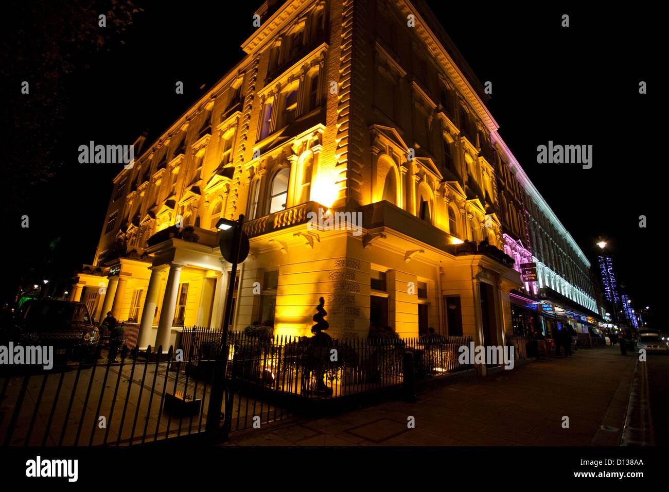 Edificio iluminado en la esquina de la calle de Londres y Sussex Gardens, Paddington, en Londres, Inglaterra, Reino Unido. Foto de stock