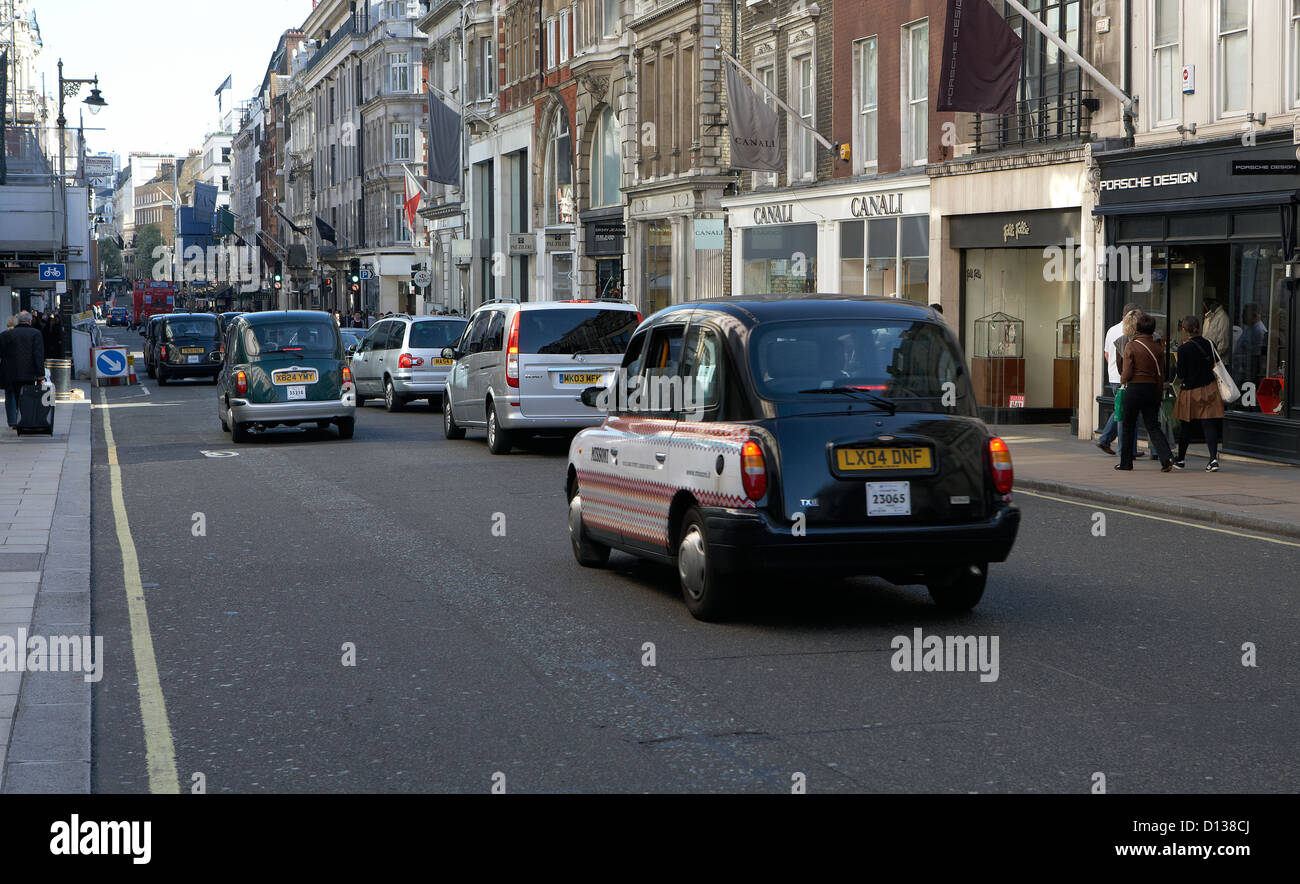 Londres, Reino Unido, tráfico y prestigiosas boutiques de New Bond Street Foto de stock