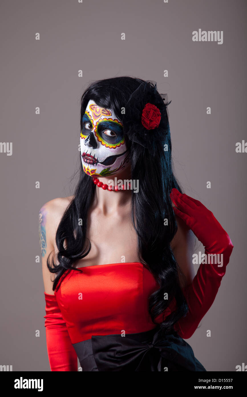 Mujer con calaveras de azúcar maquillaje vistiendo vestido rojo, el Día de  los Muertos Fotografía de stock - Alamy