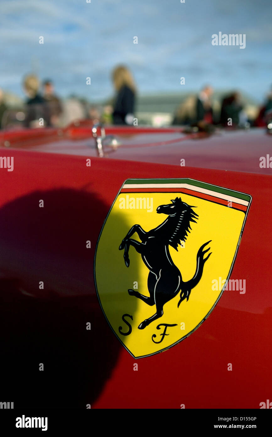 Una insignia de Ferrari en el lateral de un supercoche rojo en un car show. Foto de stock