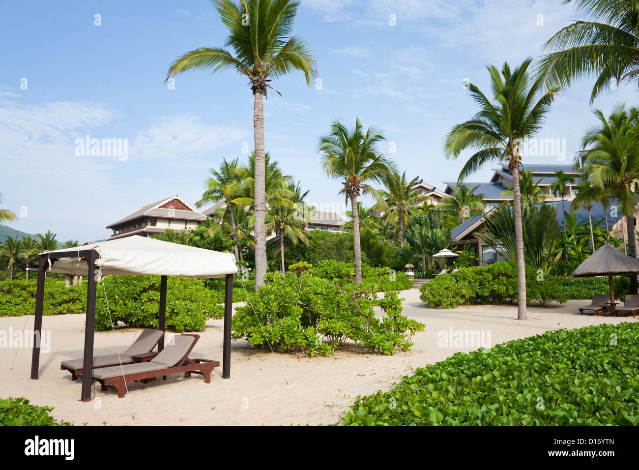 Resort tropical con camas de bronceado y parasol. Foto de stock