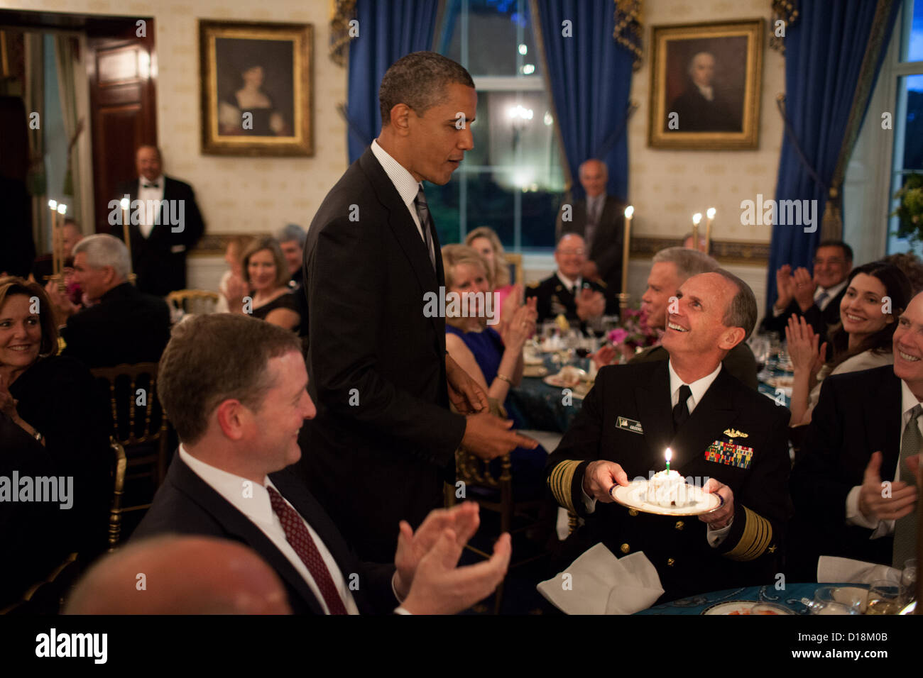 El presidente Barack Obama presenta una tarta de cumpleaños para el Almirante Jonathan Greenert, Jefe de Operaciones Navales, durante una cena de Foto de stock