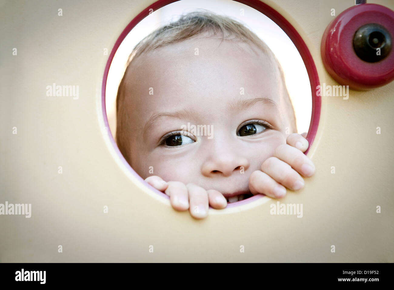 Niño Niña peeking a través de círculo Foto de stock
