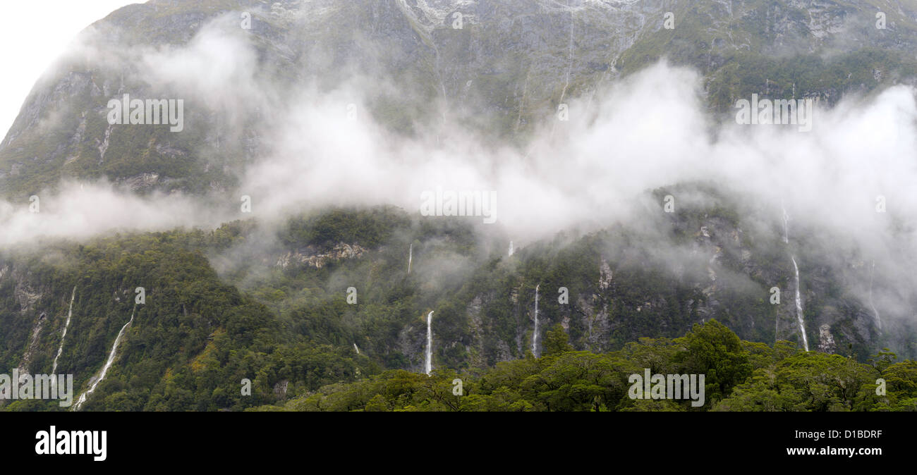 Cascada se vierte en Milford Sound/Piopiotahi después de una fuerte lluvia; el Parque Nacional Fiordland, Nueva Zelanda, junto a la autopista 94 Foto de stock