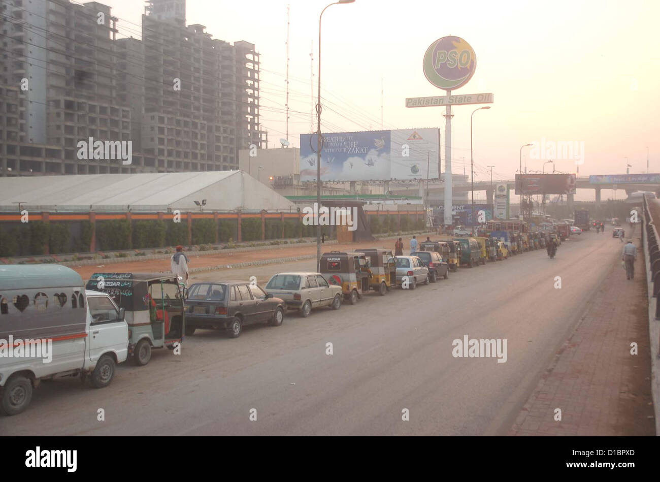 Un gran número de vehículos que están en cola esperando su turno para llenar el CNG en una estación de GNC, cerca de KPT Interchange en Karachi el viernes, 14 de diciembre de 2012. Foto de stock