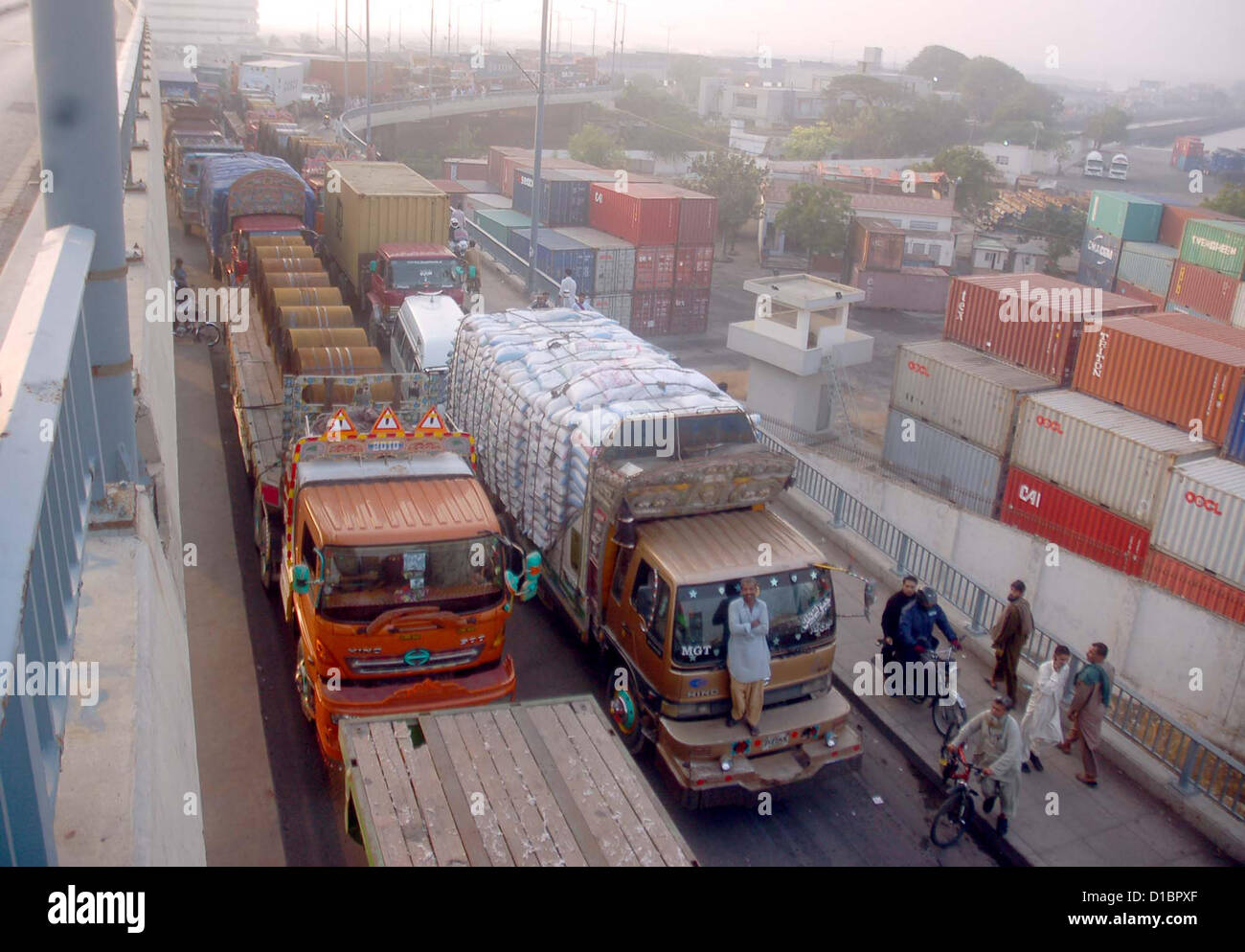 Un gran número de camiones que transportan mercancías contenedores ocupados en el transporte y en su camino tras finalizar la huelga que, convocada por la Asociación de Transporte de Mercancías, cerca del puente del Maripur Netty Jetty Road en Karachi el viernes, 14 de diciembre de 2012. Foto de stock