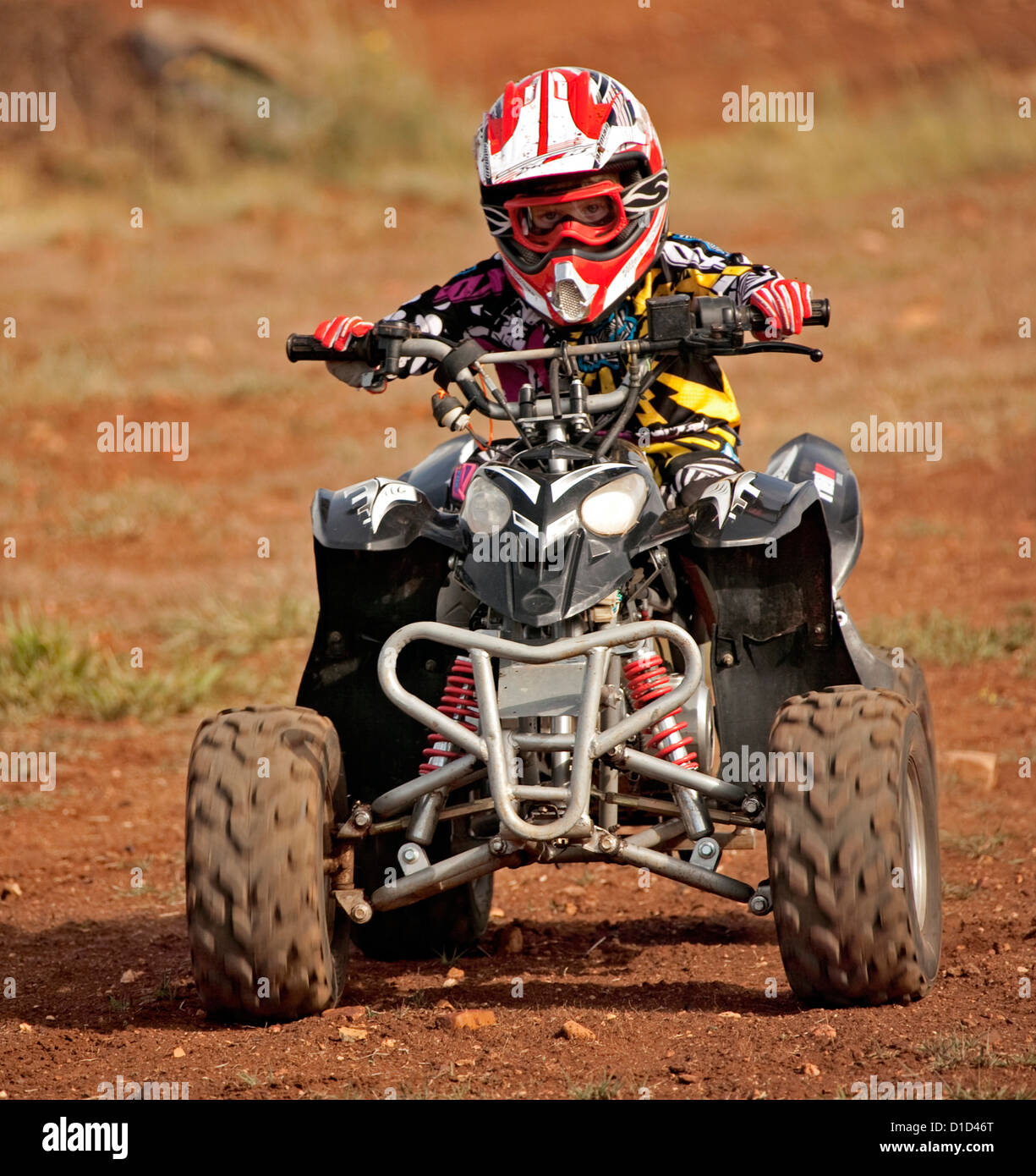 Niño - cuatro años - en Quad bike usando ropa protectora y cabalgando sobre  pista de tierra Fotografía de stock - Alamy