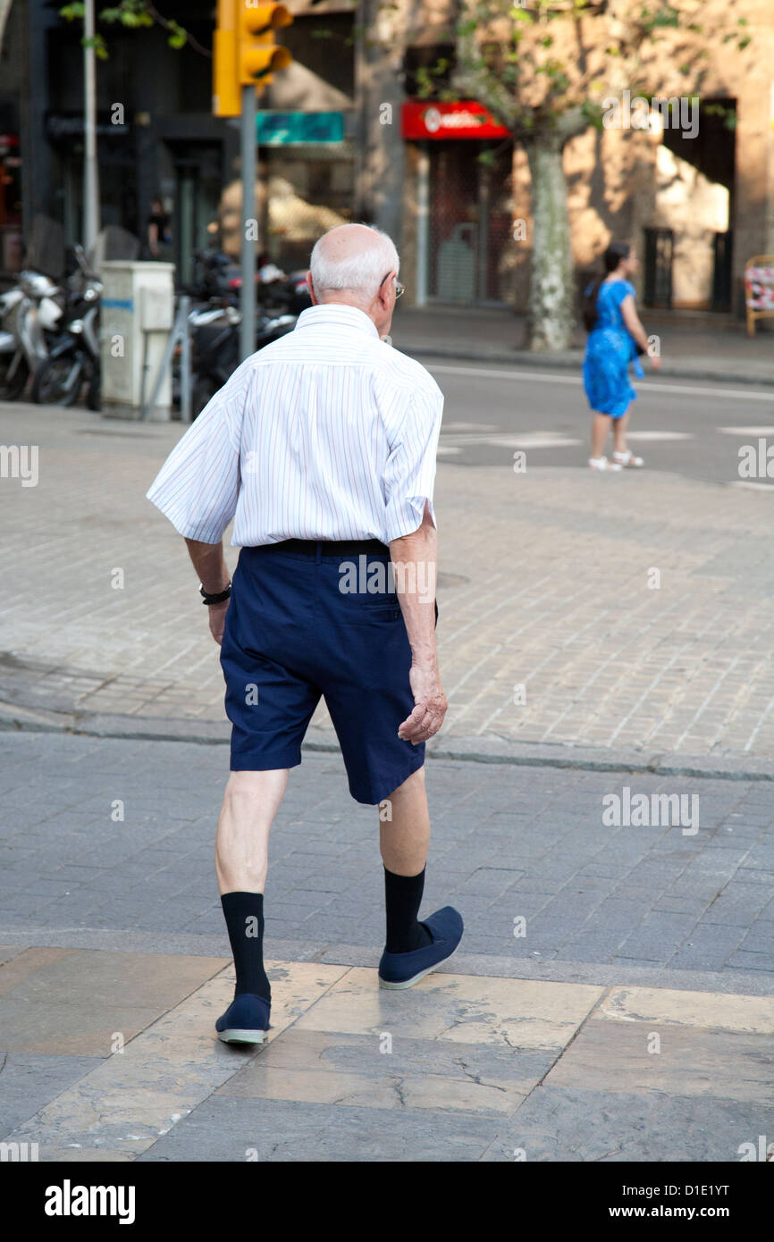 Viejo hombre caminando en la calle vistiendo pantalones cortos Fotografía  de stock - Alamy