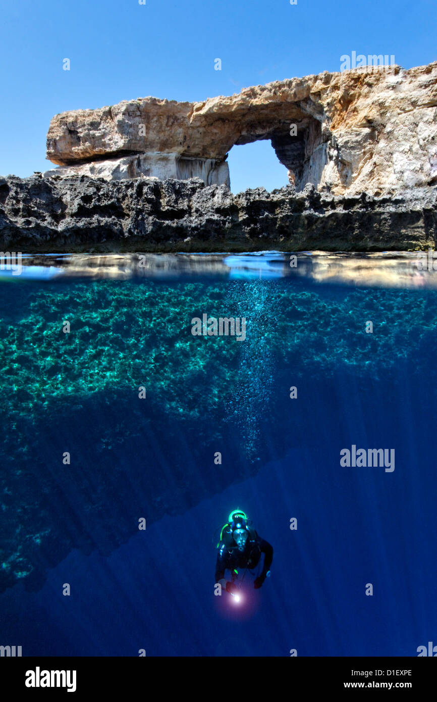 Split shot mitad y mitad con diver y arco de roca ventana azul en el Mar Mediterráneo cerca de Gozo, Malta Foto de stock