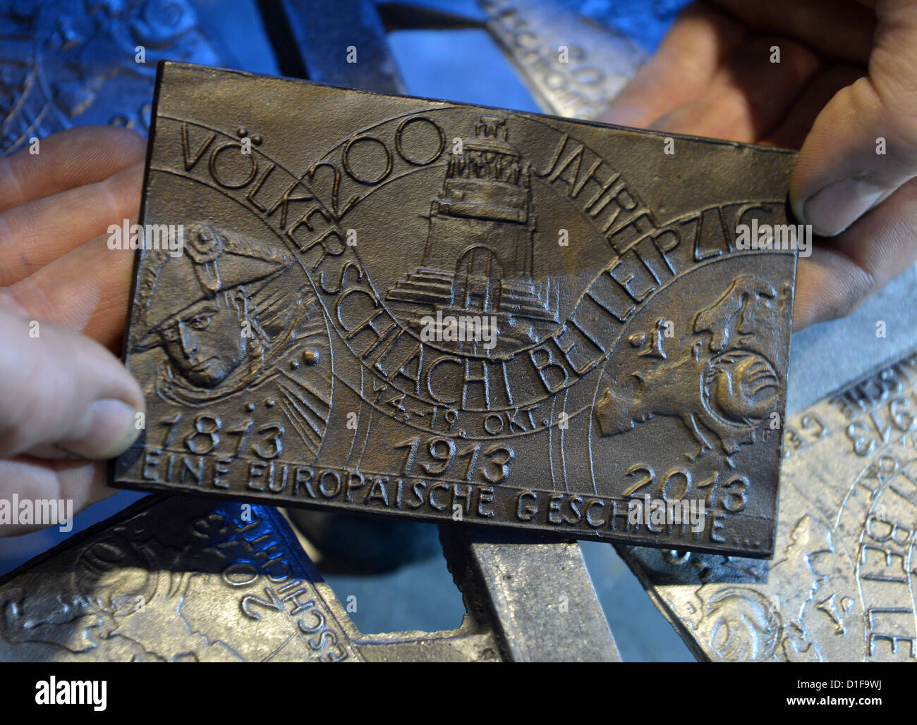 Un empleado de la foundary Freiberg de la Universidad de Minería y Tecnología examens la medalla de fundición para el aniversario de la batalla de las naciones en Freiberg (Sajonia), Alemania, el 18 de diciembre de 2012. Las medallas para el 200 aniversario de la batalla están hechas de bolas de cañón desde 1813 encontrados en los campos de batalla alrededor de Leipzig. Inicialmente, se trata de una edición limitada de 600 medallas. Foto: Hendrik Schmidt Foto de stock