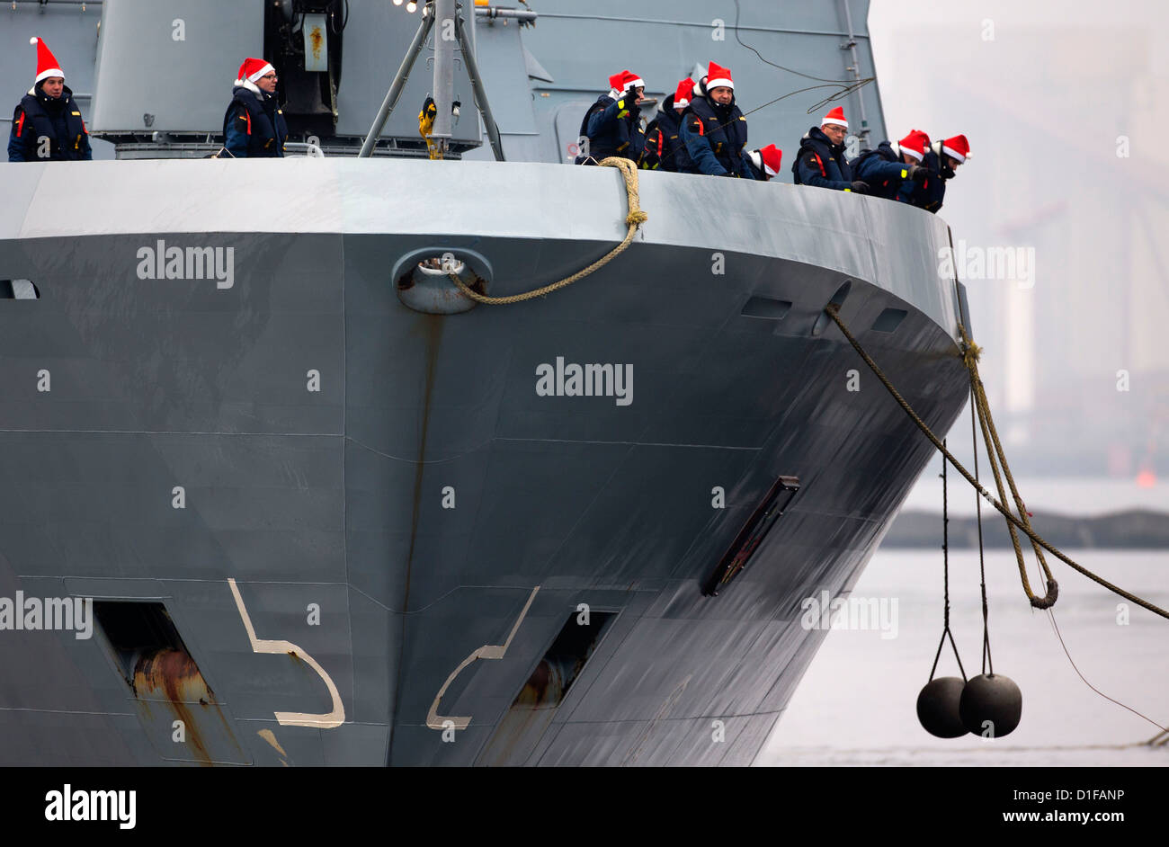 Miembros de la tripulación en la cubierta de la corbeta 'Magdeburg', de regreso de su misión a Líbano Rostock-Hohe Duene, Alemania, el 19 de diciembre de 2012. Los 58 infantes de marina estaban estacionadas en la costa libanesa durante tres meses. Fotografía: JENS BUETTNER Foto de stock