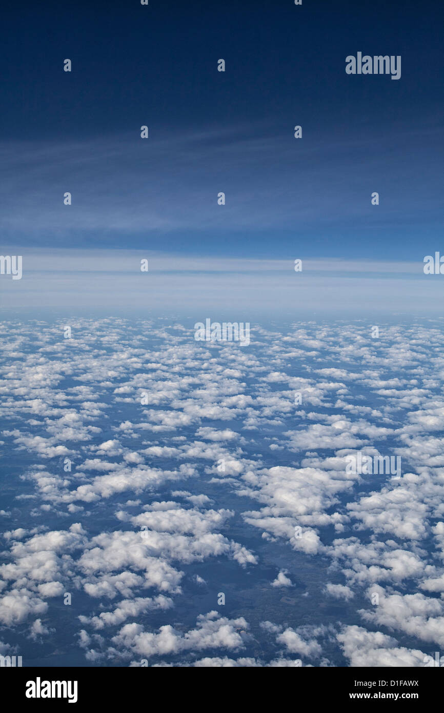 Blancas nubes hinchadas, cielo azul profundo, visto desde y avión Foto de stock