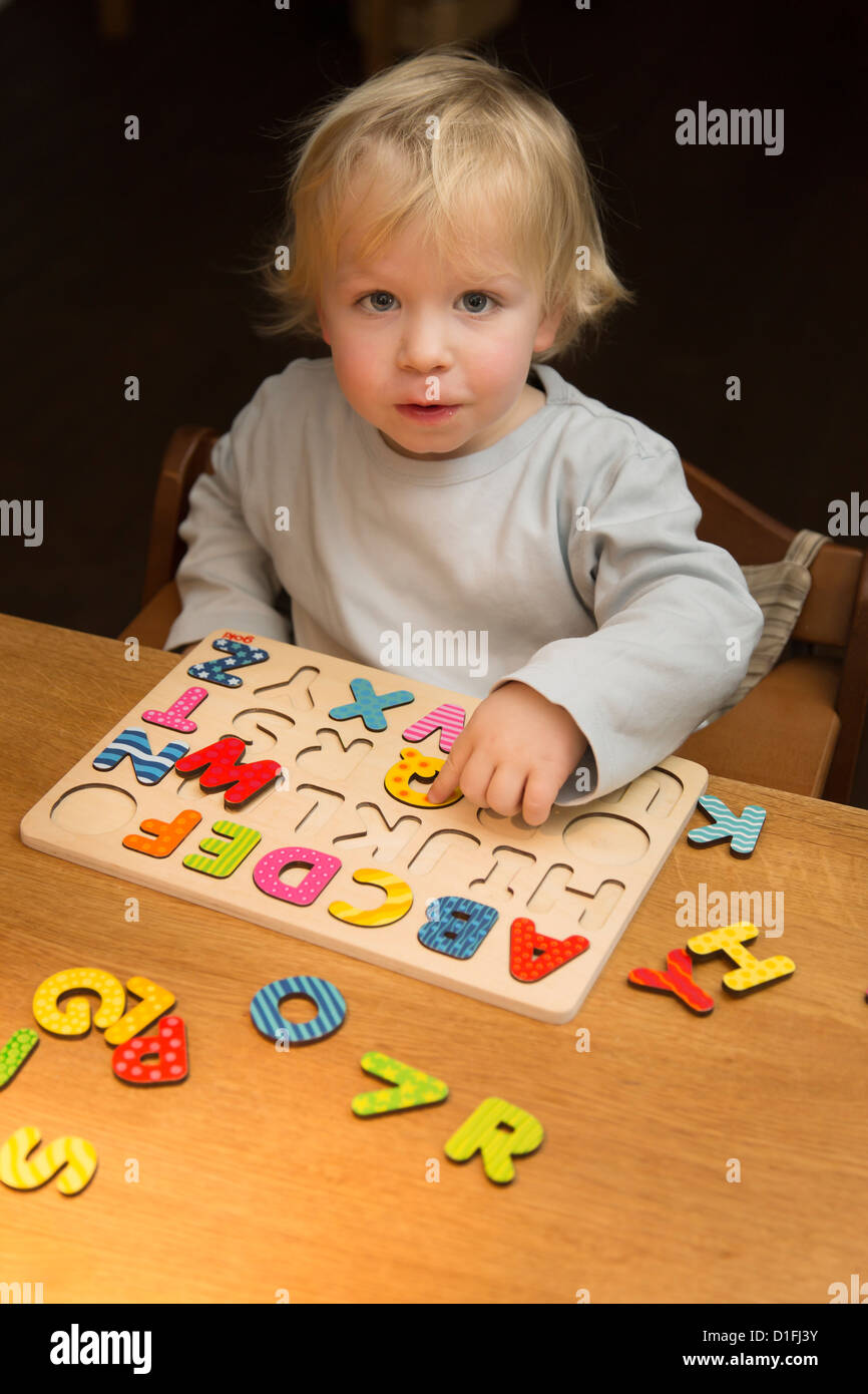 Joven, de 2 años, jugando con un rompecabezas, alfabeto ABC Foto de stock