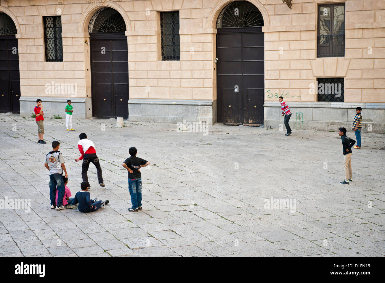Los niños migrantes de Bangladesh jugar críquet en una plaza de Palermo Viejo, Italia Foto de stock