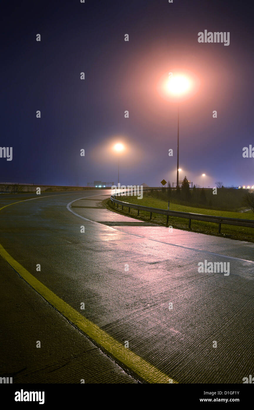 Rampa de carretera y luz de noche, con niebla lluvia niebla Foto de stock