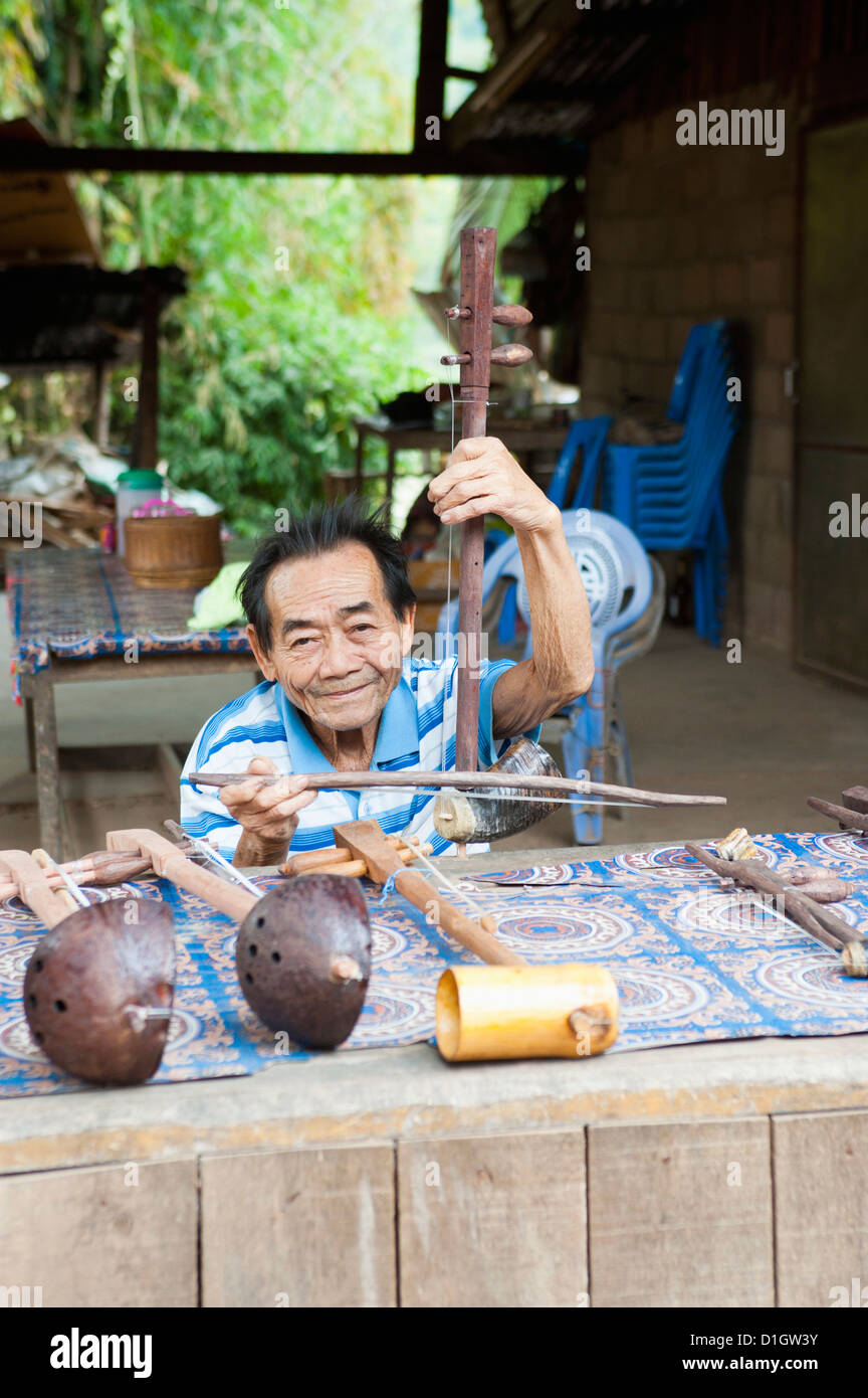 Hombre tocando el vendedor de instrumentos musicales artesanales, Luang Prabang, Laos, Indochina, en el sudeste de Asia, Asia Foto de stock