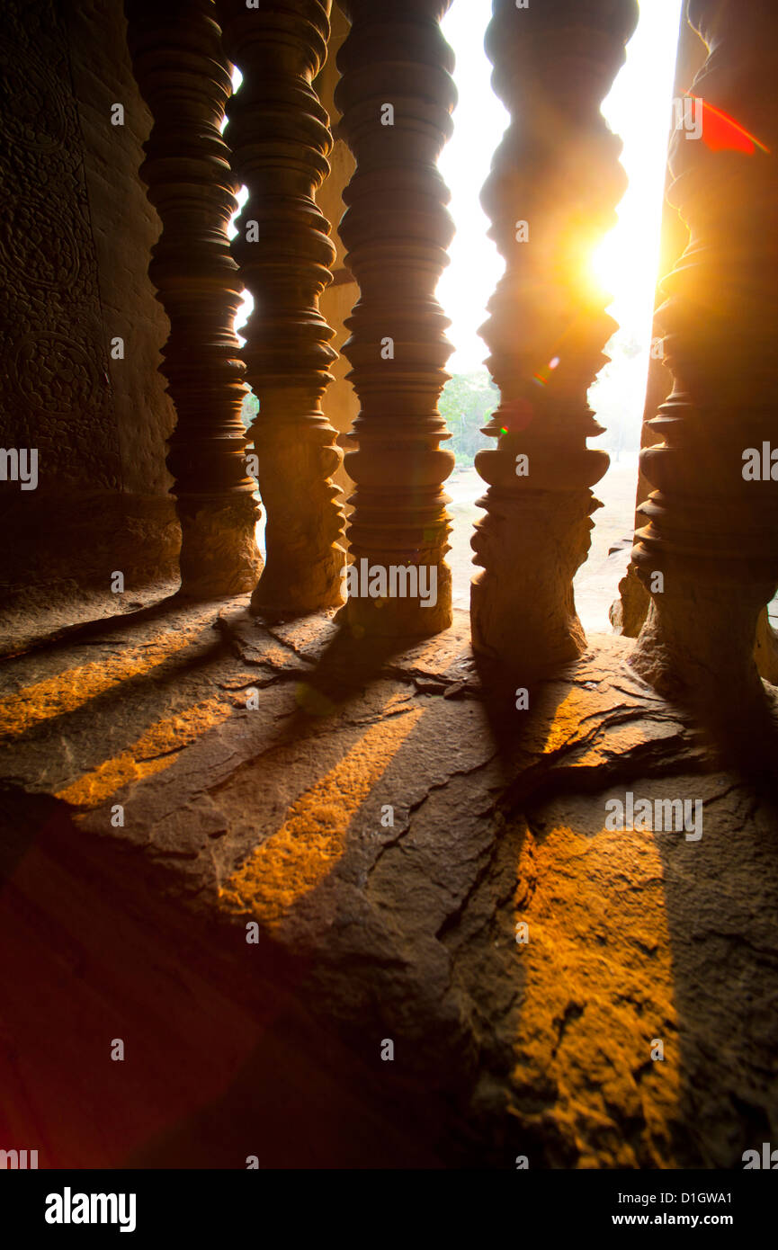 Puesta de sol a través de los pilares de piedra en Angkor Wat, el complejo de templos de Angkor, de la provincia de Siem Reap, Camboya, en Indochina, en el sudeste de Asia, Asia Foto de stock