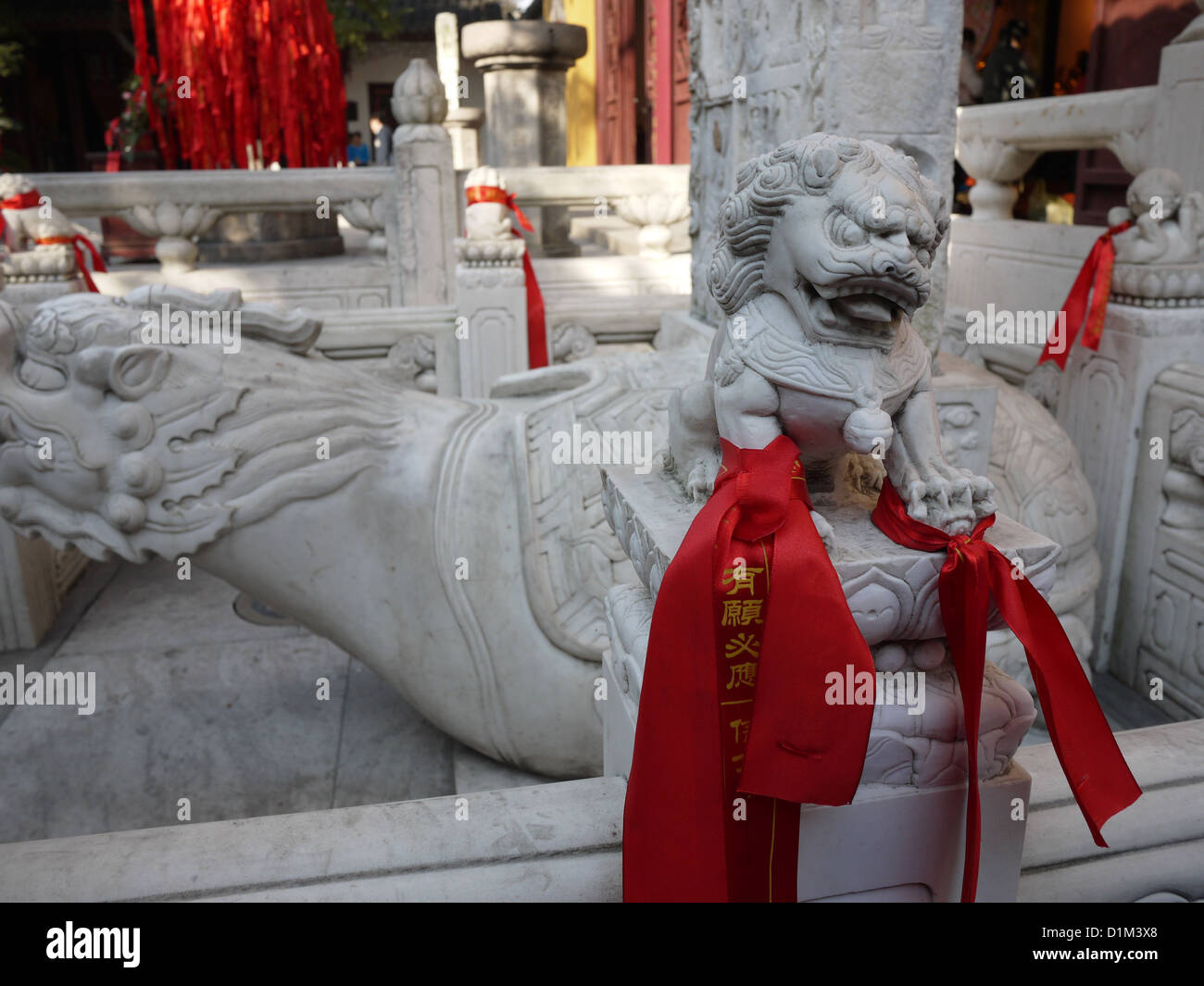León chino escultura estatua esculpida en piedra de cinta roja Foto de stock