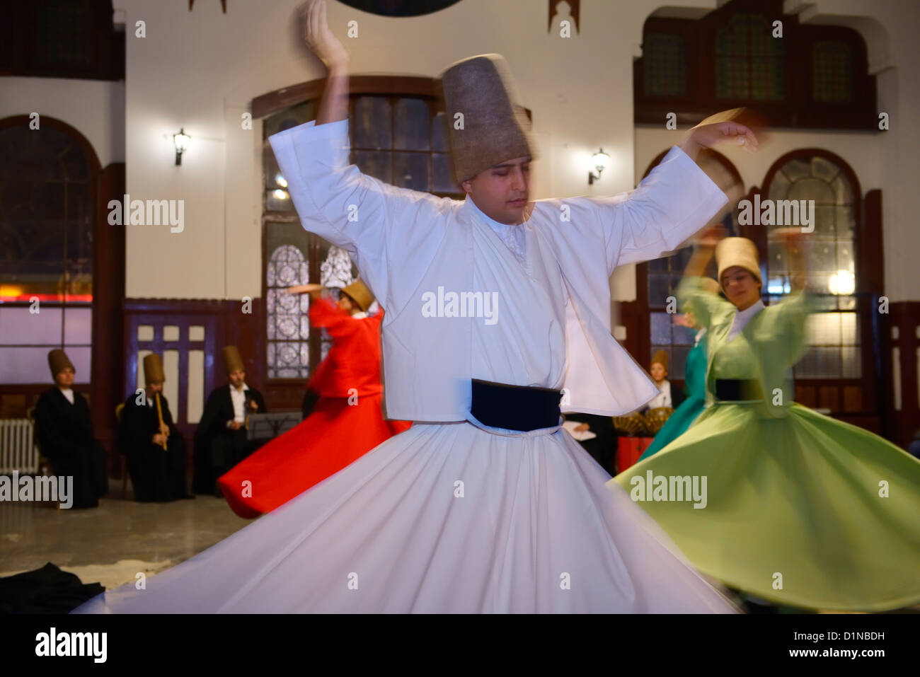 Macho Torbellino Sufi Derviche en una ceremonia Sema con músicos y la mujer en la estación de tren de Estambul TURQUÍA Foto de stock