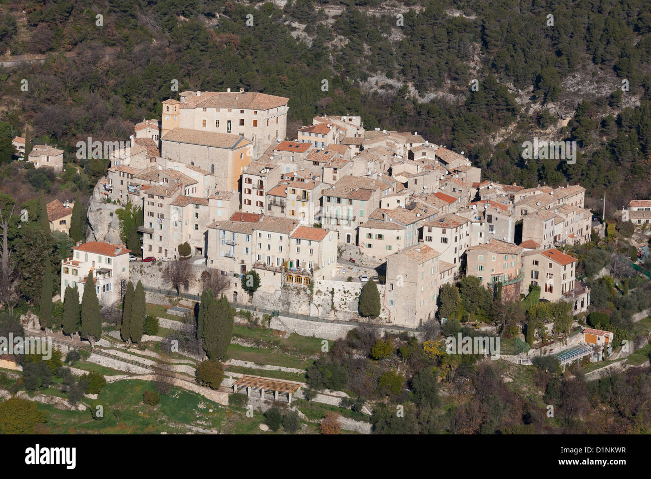 VISTA AÉREA. Pueblo medieval en la cima de la colina. Carros, el interior de la Riviera Francesa, Francia. Foto de stock