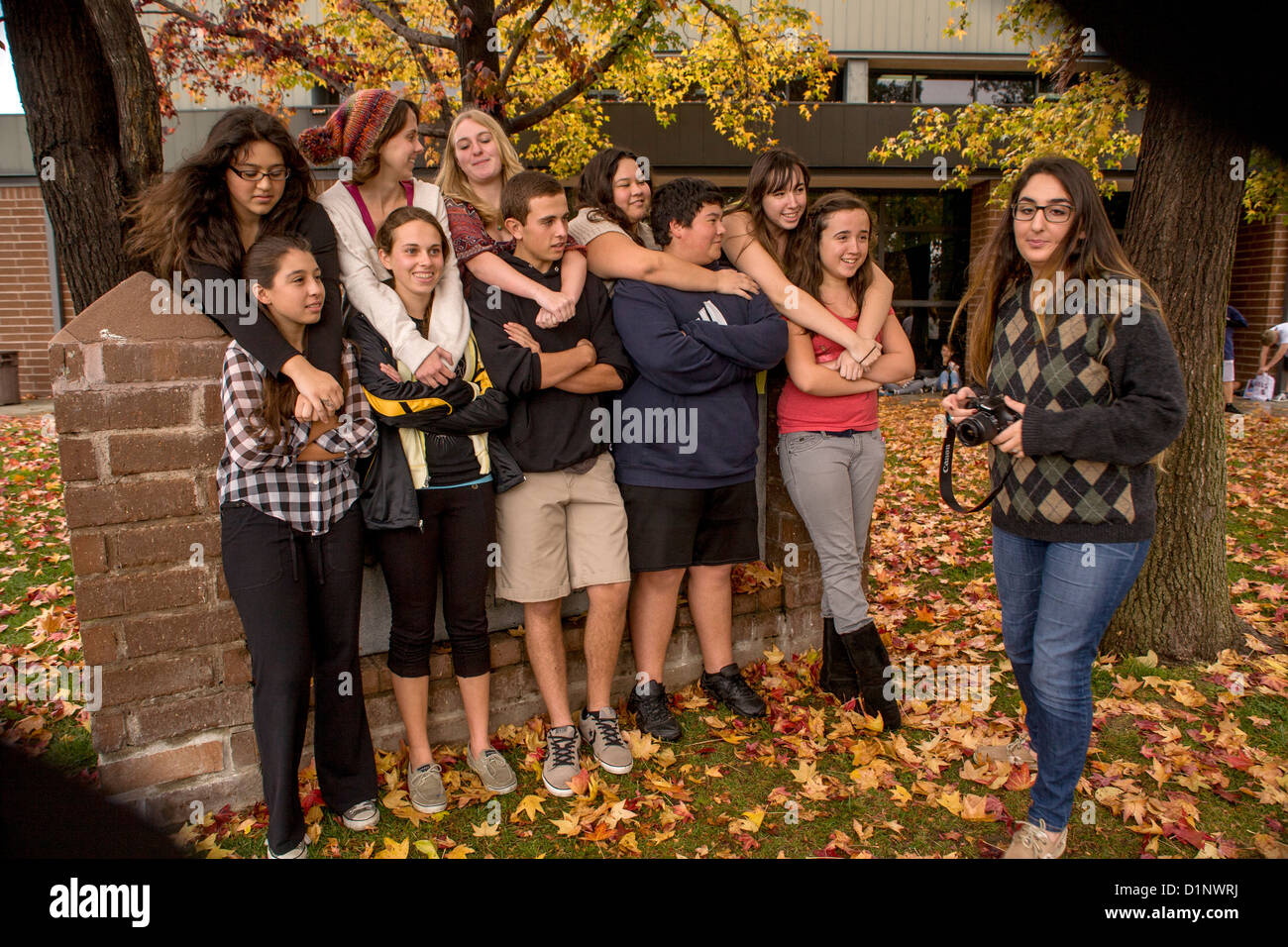 Estudiantes de Secundaria de California multiétnica posan para la cámara, un compañero de clase en la escuela al aire libre del campus. Foto de stock