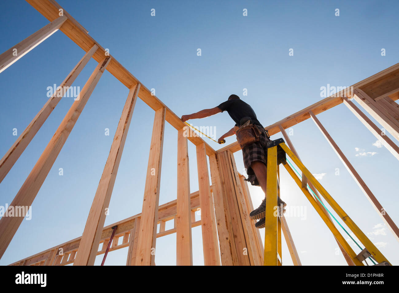 Hombre caucásico bastidor de medición en sitio en construcción Foto de stock