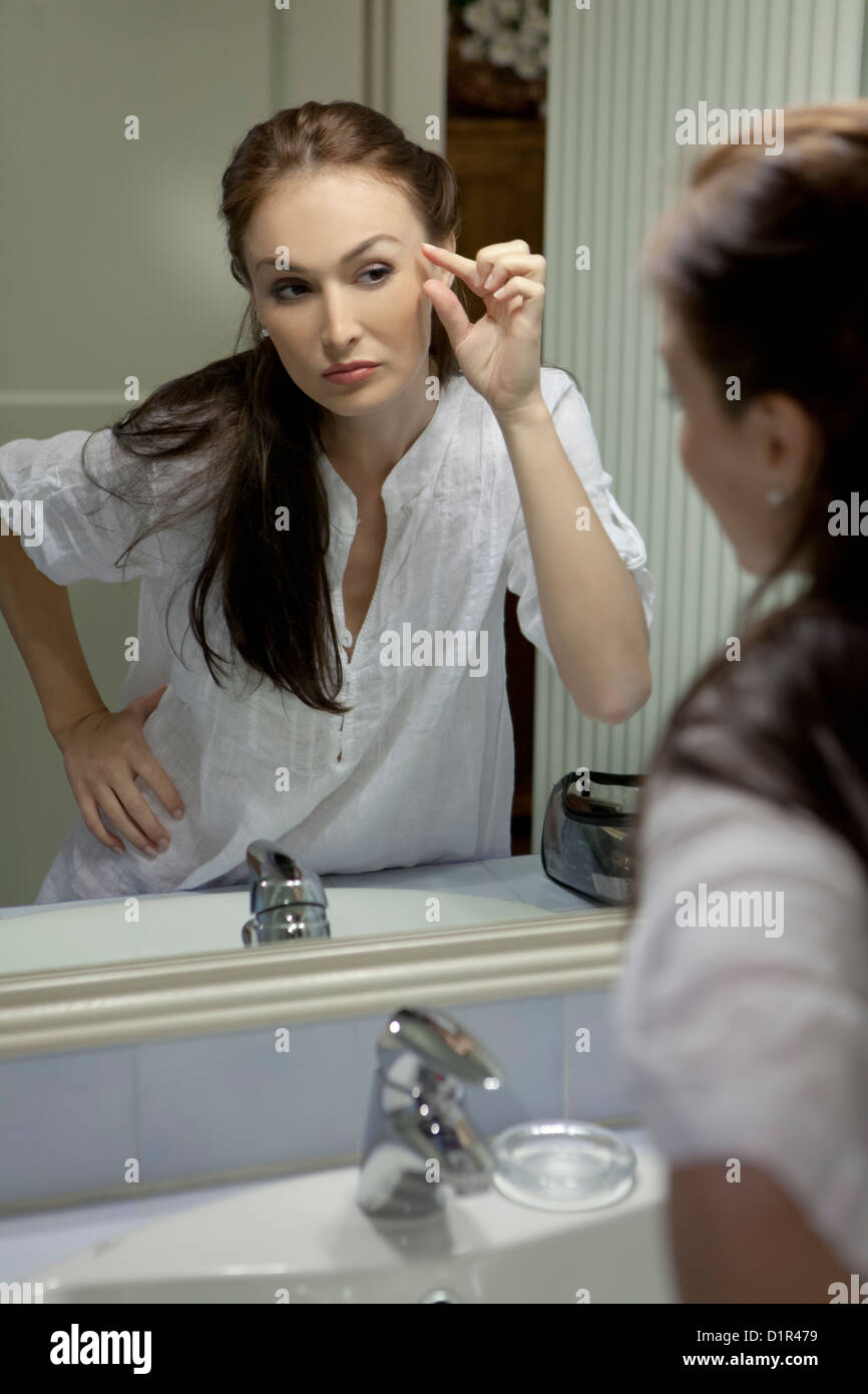 Mujer en el espejo, echa un vistazo a las arrugas Foto de stock