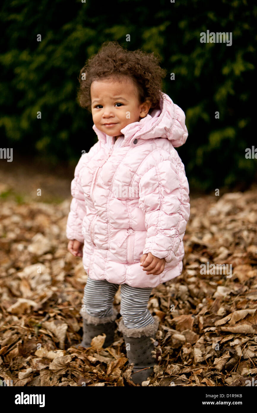 Linda niña niño jugando en hojas caídas Foto de stock