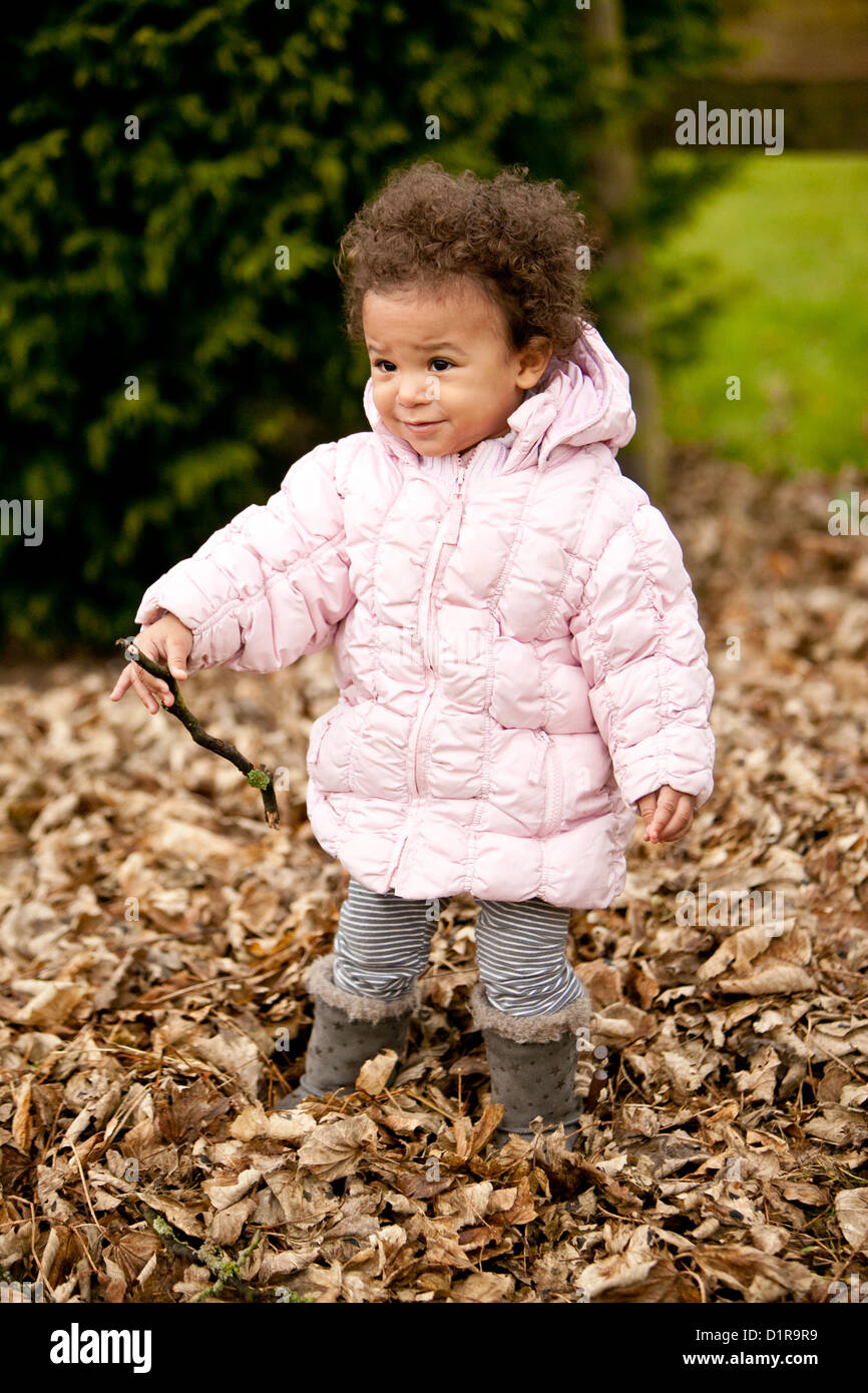 Linda niña niño jugando en hojas caídas Foto de stock