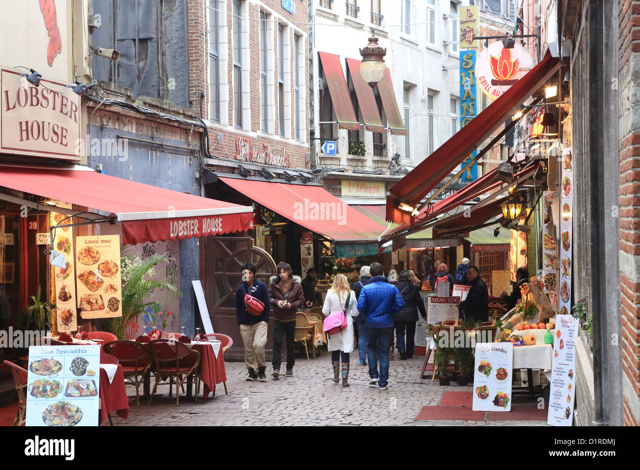 Los turistas caminando por los restaurantes en la Rue des Beenhouwers Straat, en el casco antiguo de la ciudad, Bruselas, Bélgica Foto de stock