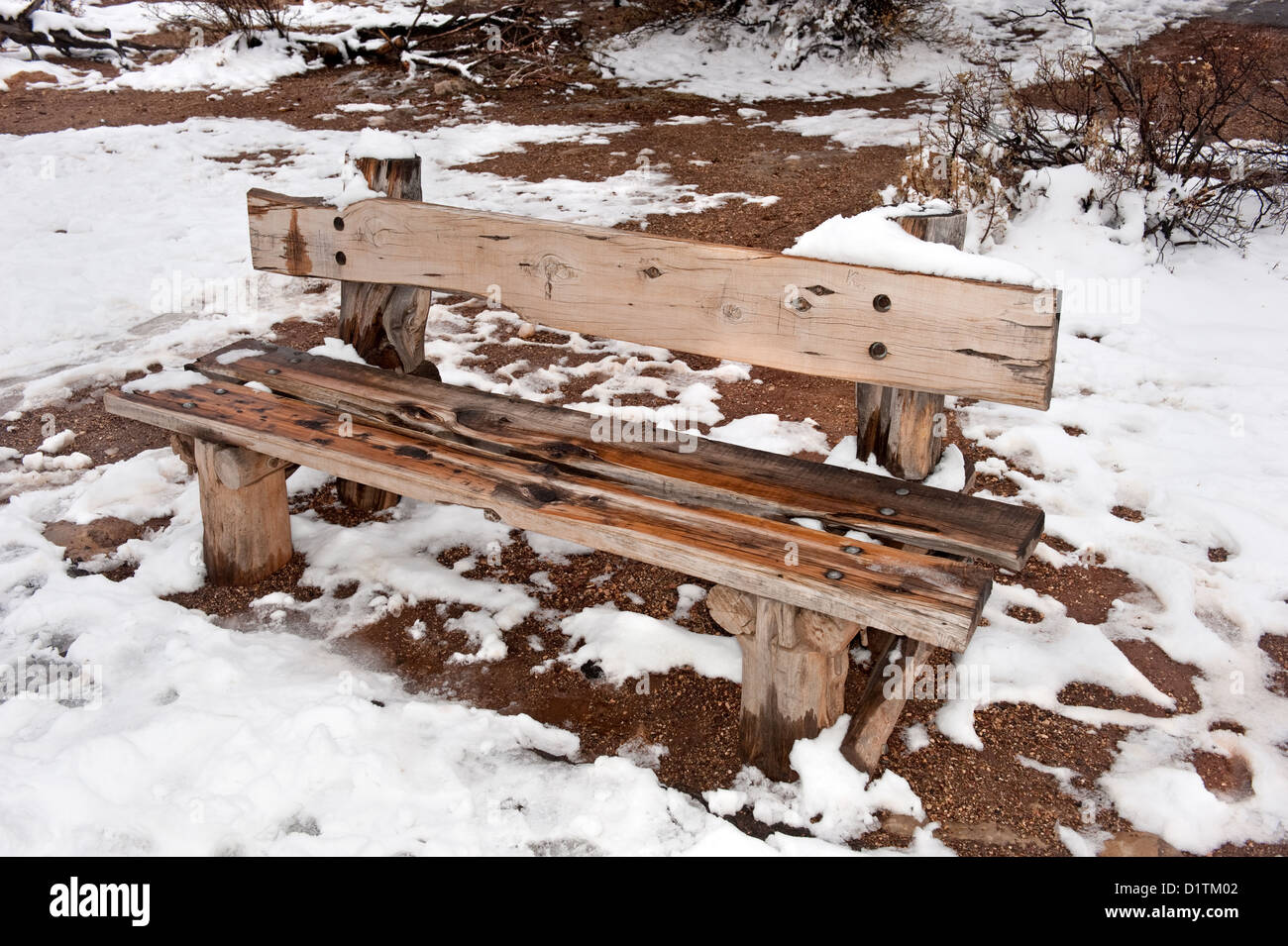 Una húmeda y fría en un banco de un parque de madera durante un día nevado Winder. Foto de stock