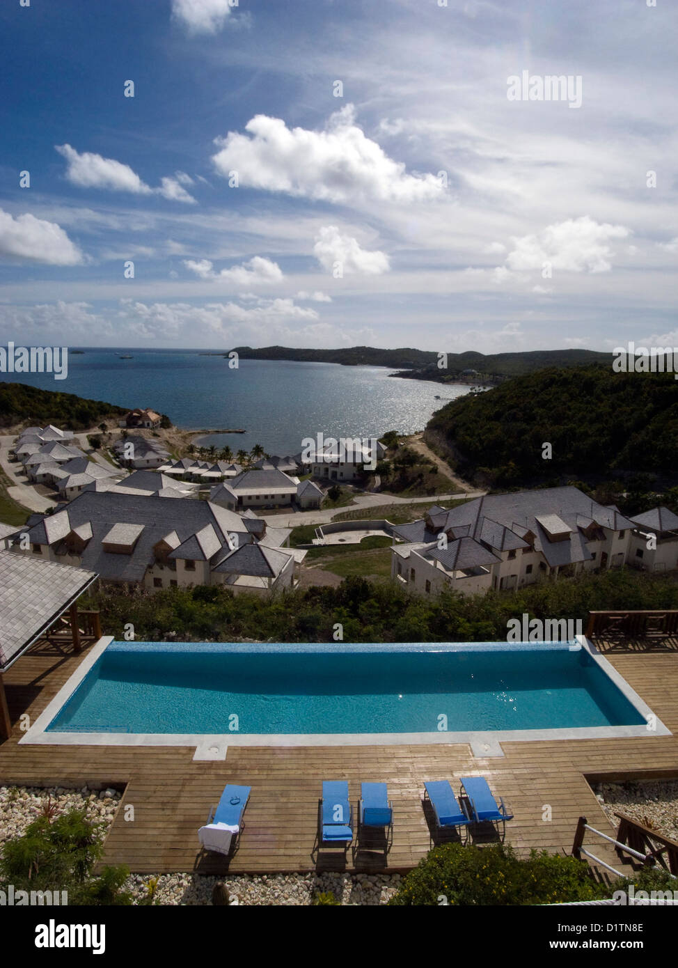 Una piscina de borde infinito bajo un cielo azul en un resort en la isla de Antigua en el Caribe. Foto de stock