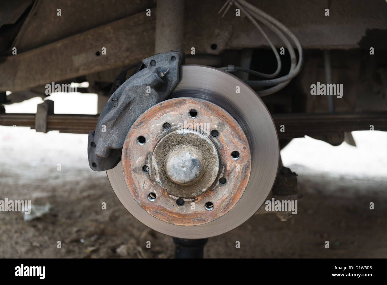 Freno de disco delantero en un coche viejo en proceso de montaje y sustitución de neumáticos dañados Foto de stock