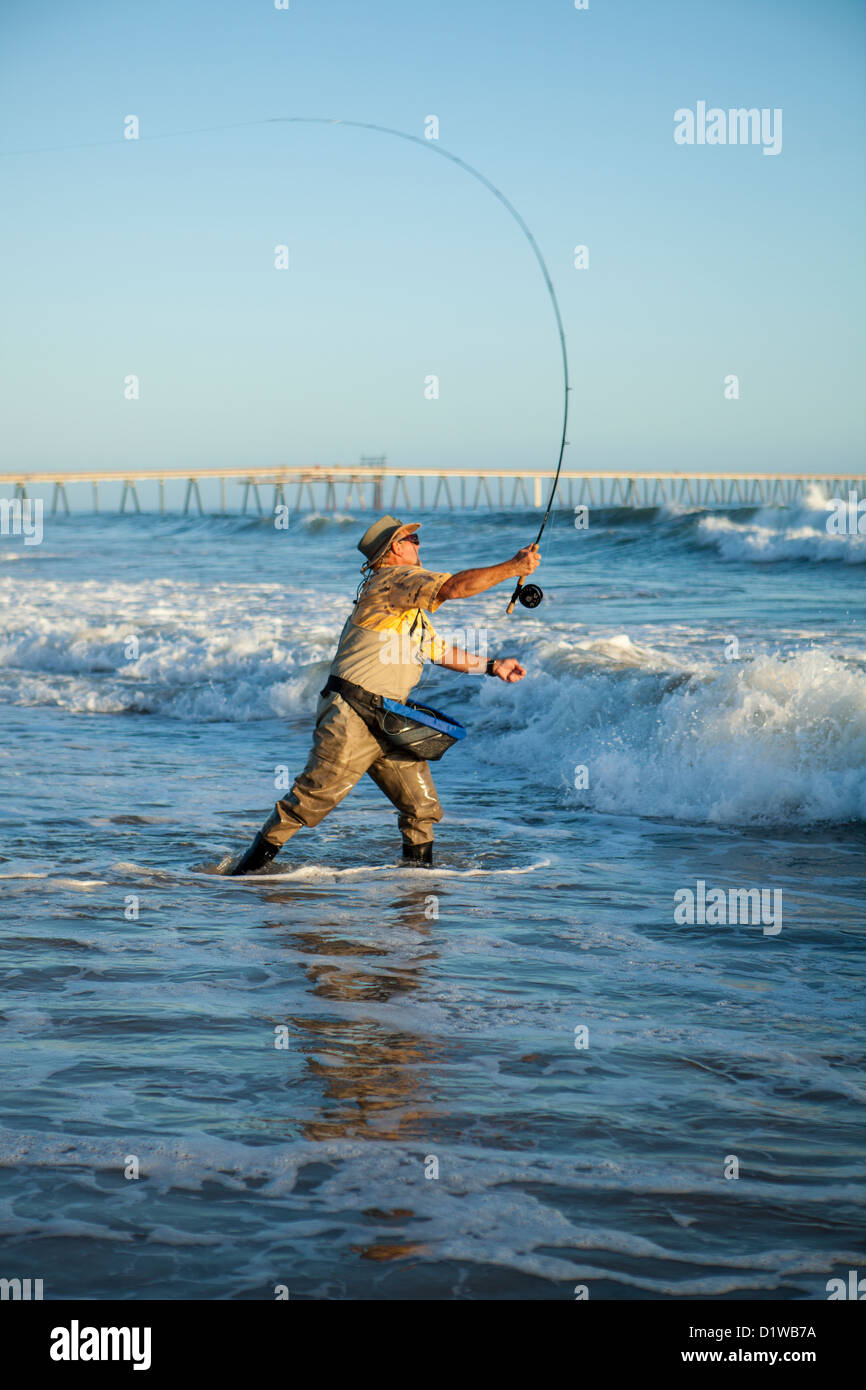 Pescador con mosca surf casting de perca, La Conchita playa cerca de Carpinteria, California, Estados Unidos de América Foto de stock