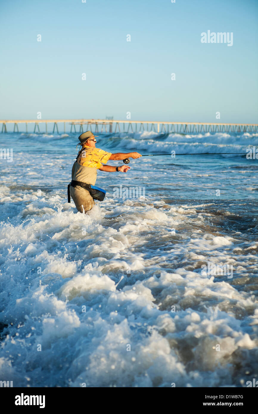 Pescador con mosca surf casting de perca, La Conchita playa cerca de Carpinteria, California, Estados Unidos de América Foto de stock