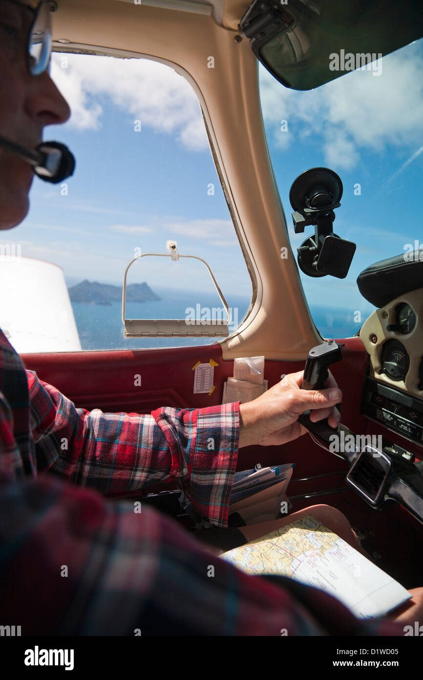 Un piloto a los mandos de una avioneta, sobrevolando Northland, Isla del Norte, Nueva Zelanda. Foto de stock