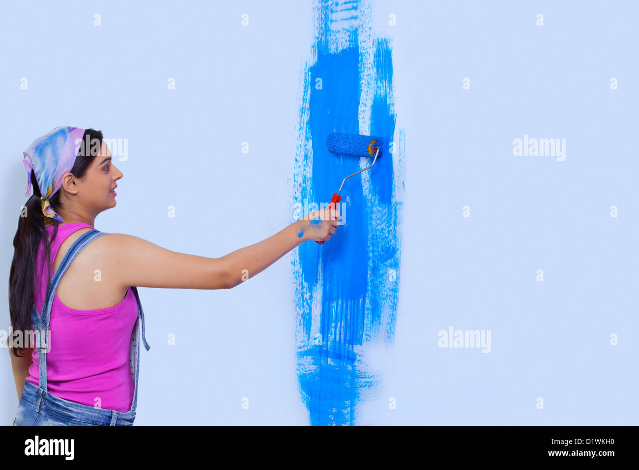 Mujer joven pintando su casa wall Fotografía de stock - Alamy