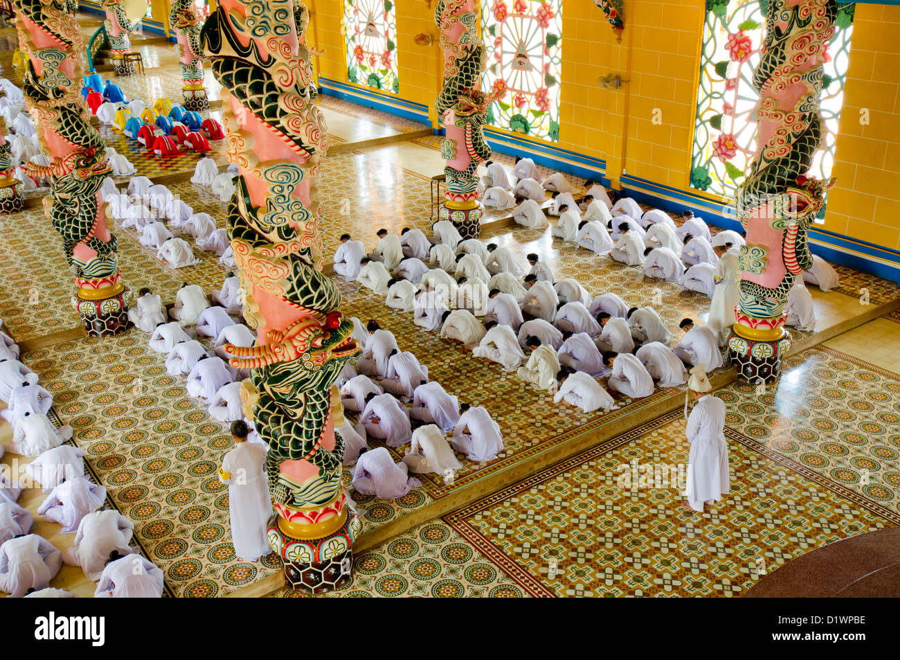 Adoradores al mediodía la oración en el templo Cao Dai, Tay Ninh, Vietnam, Asia Foto de stock