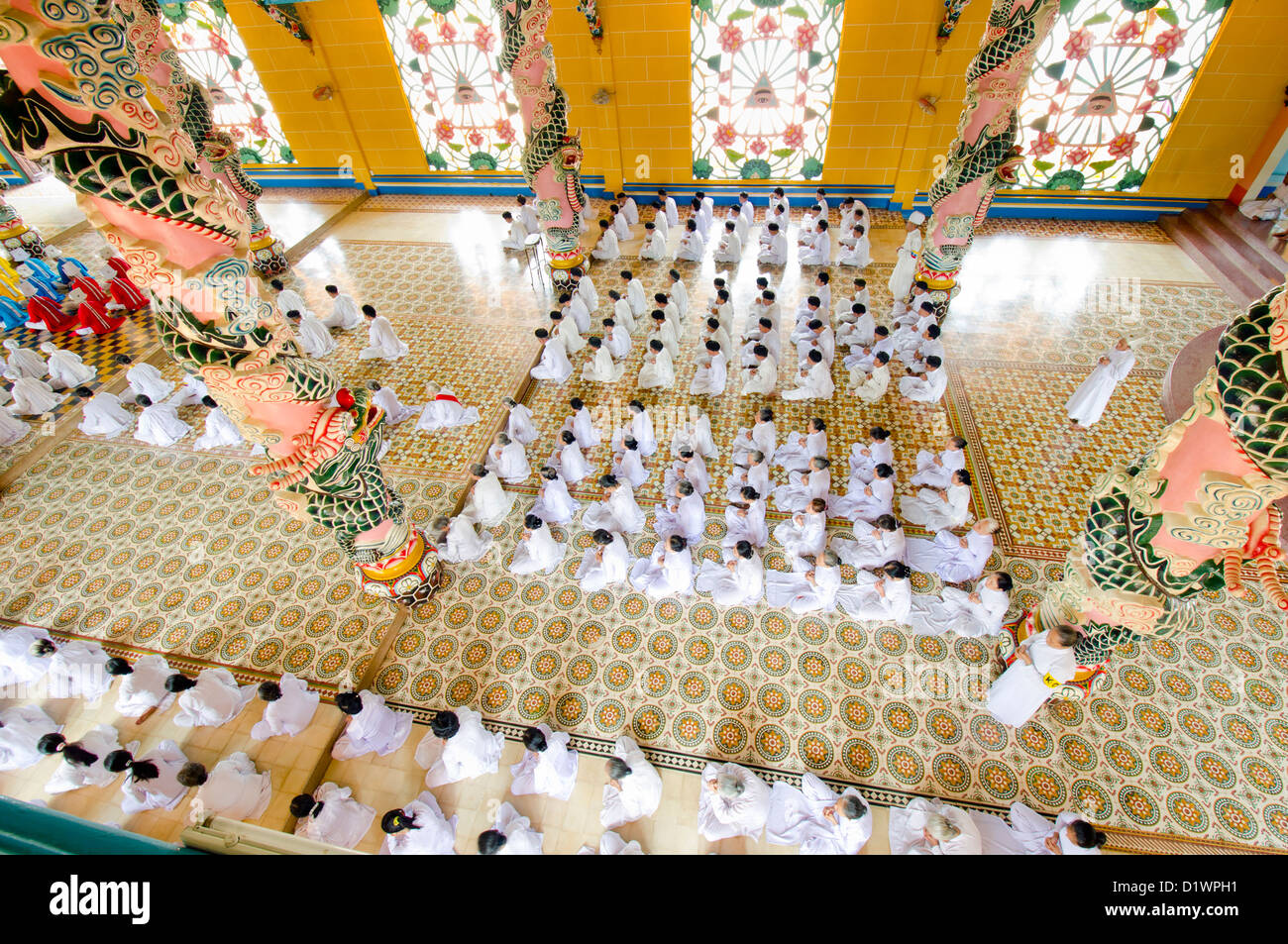 Adoradores al mediodía la oración en el templo Cao Dai, Tay Ninh, Vietnam, Asia Foto de stock