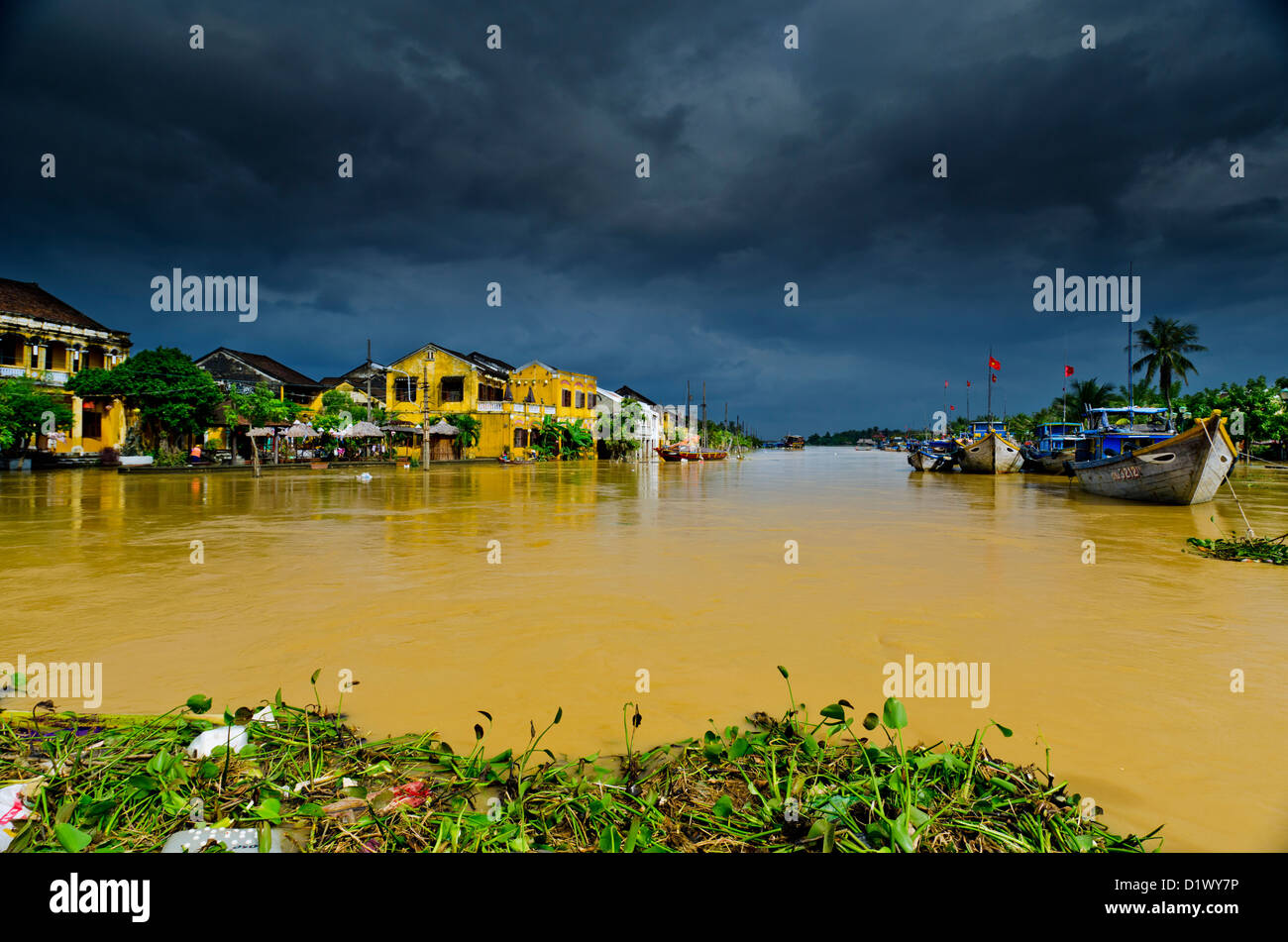 Ominosas nubes reunir más inundado ya río Thu Bon, Hoi An, Vietnam Foto de stock