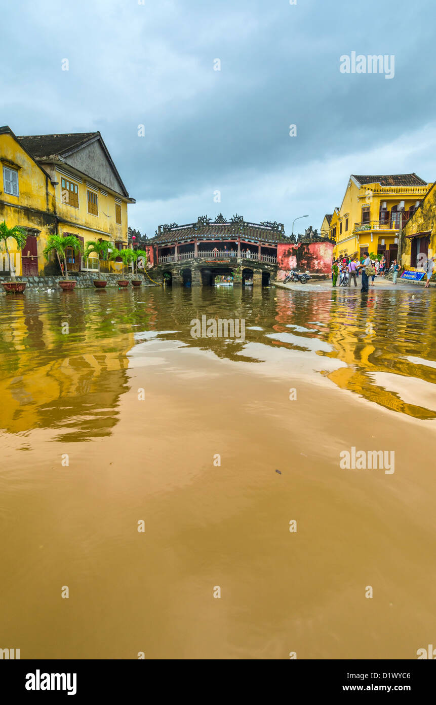 Los turistas se reúnen para ver las inundaciones alrededor del puente japonés, Hoi An, Vietnam Foto de stock