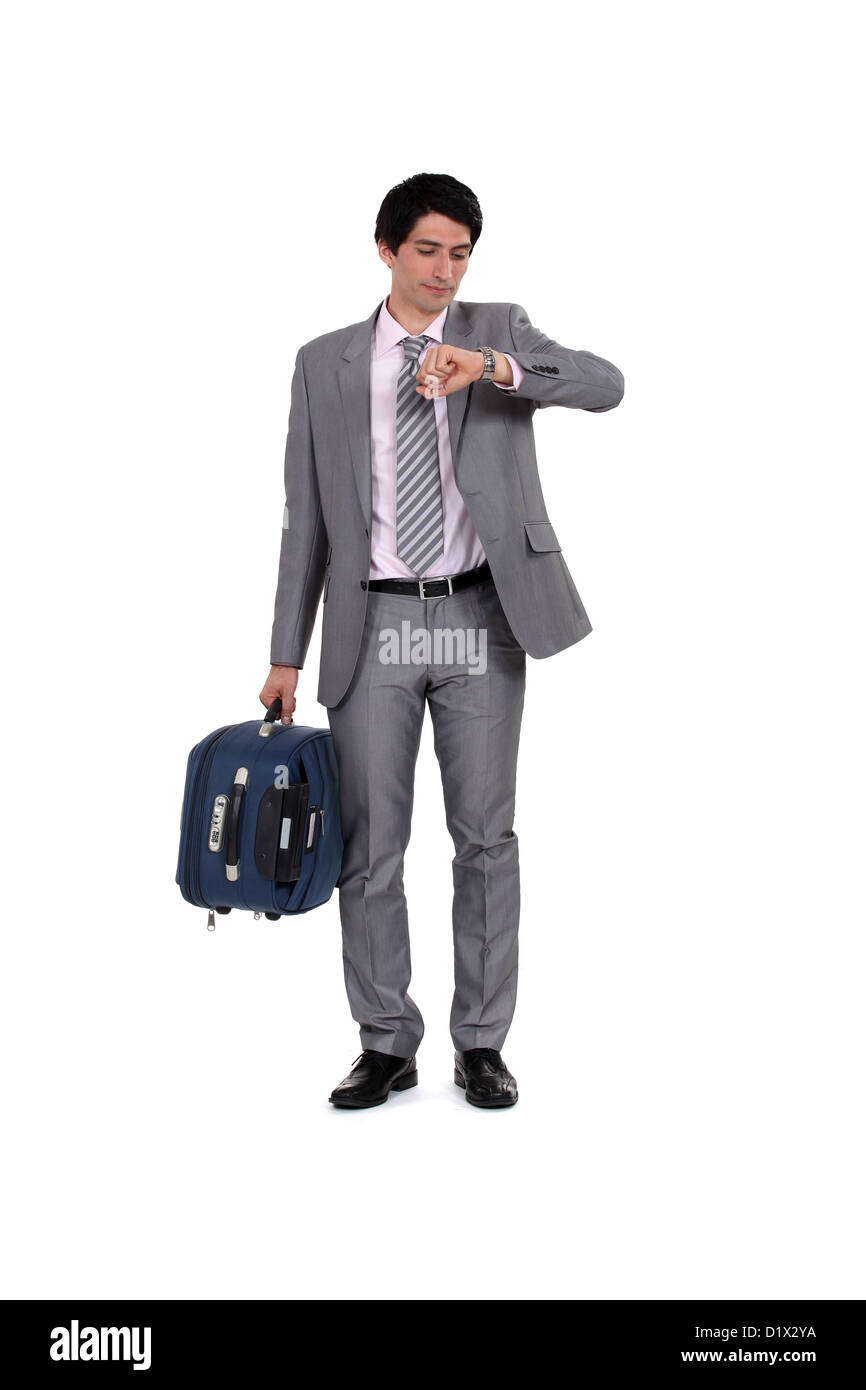 Hombre con maleta mirando el tiempo Fotografía de stock - Alamy