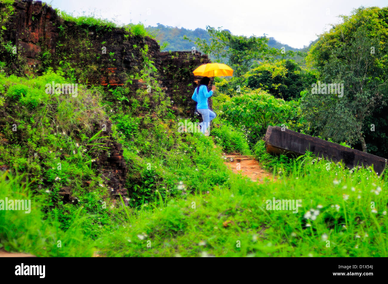 Las mujeres con paraguas amarillo, mi hijo, ruinas del antiguo reino de Champa, Vietnam, Asia Foto de stock