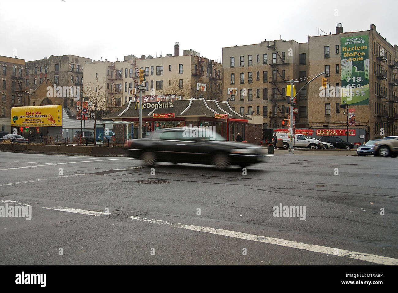 Un coche de conducción a través de una intersección en Harlem, en la Ciudad de Nueva York Foto de stock