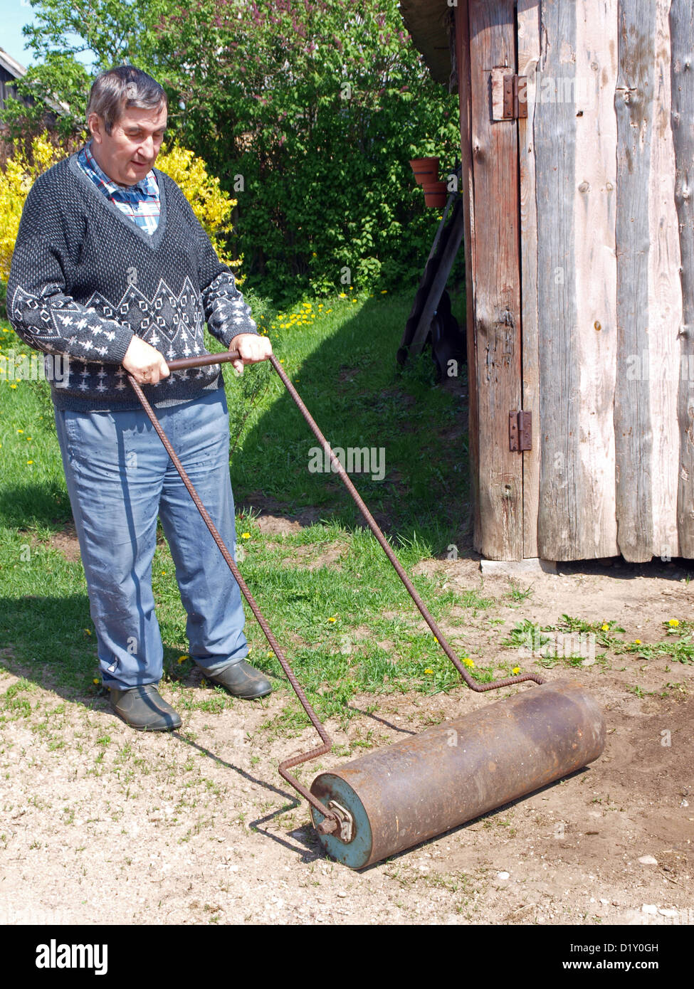 Rodillo superior de hombre terreno en patio casero por rodillo metálico  Fotografía de stock - Alamy