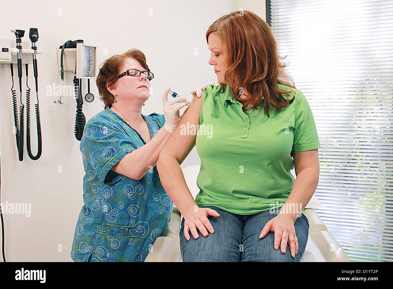 Una enfermera administra Fluzone®, y la vacuna contra el virus de la gripe intradérmica, una mujer paciente clínica Foto de stock